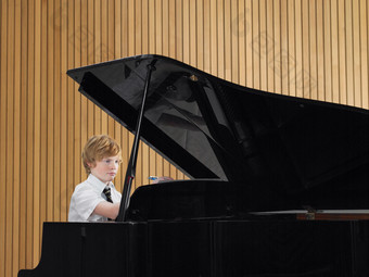 弹钢琴的小男孩摄影图