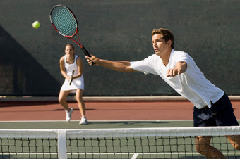 深色在打网球的年轻夫妻摄影图