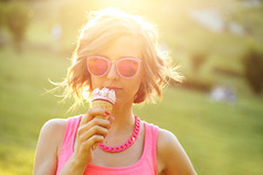 阳光下女孩草坪上吃冰淇淋