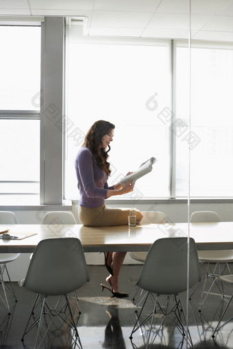 坐在会议桌看书的女人
