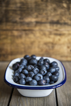 暗色调一小盘蓝莓摄影图