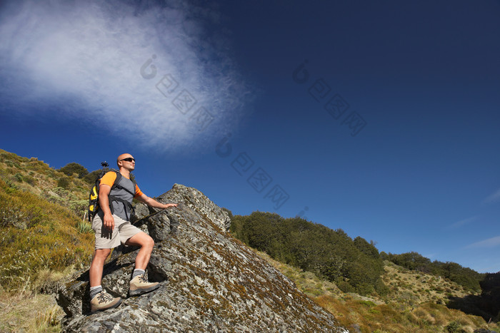 深色调在登山的人摄影图