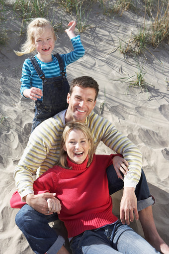 深色调沙滩上的家人们摄影图
