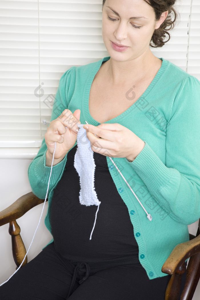 简约织衣服的孕妇摄影图