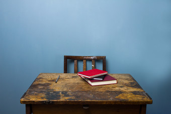 蓝色调破旧桌子上的书本摄影图