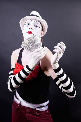 暗色调拿钱的小丑摄影图