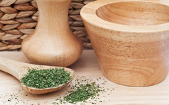 木桌上的砂浆和绿色草药