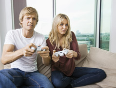 简约玩游戏机的夫妻摄影图