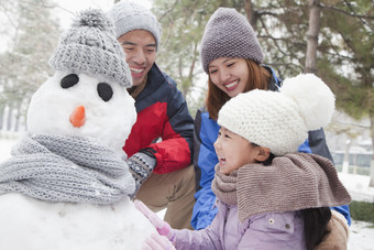 堆雪人的一家人摄影图