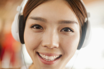 女人成熟的戴耳机听音乐客服服务沟通微笑