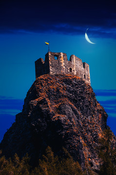 深色调山上的城堡摄影图