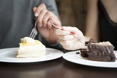深色调吃蛋糕的情侣摄影图