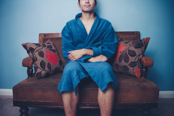 穿浴袍坐沙发上的男人