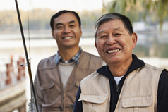 两个男人户外钓鱼河边码头微笑新鲜的鱼鱼竿