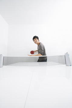 灰色调打乒乓球的男人摄影图
