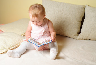 坐在沙发上<strong>看书</strong>的宝宝