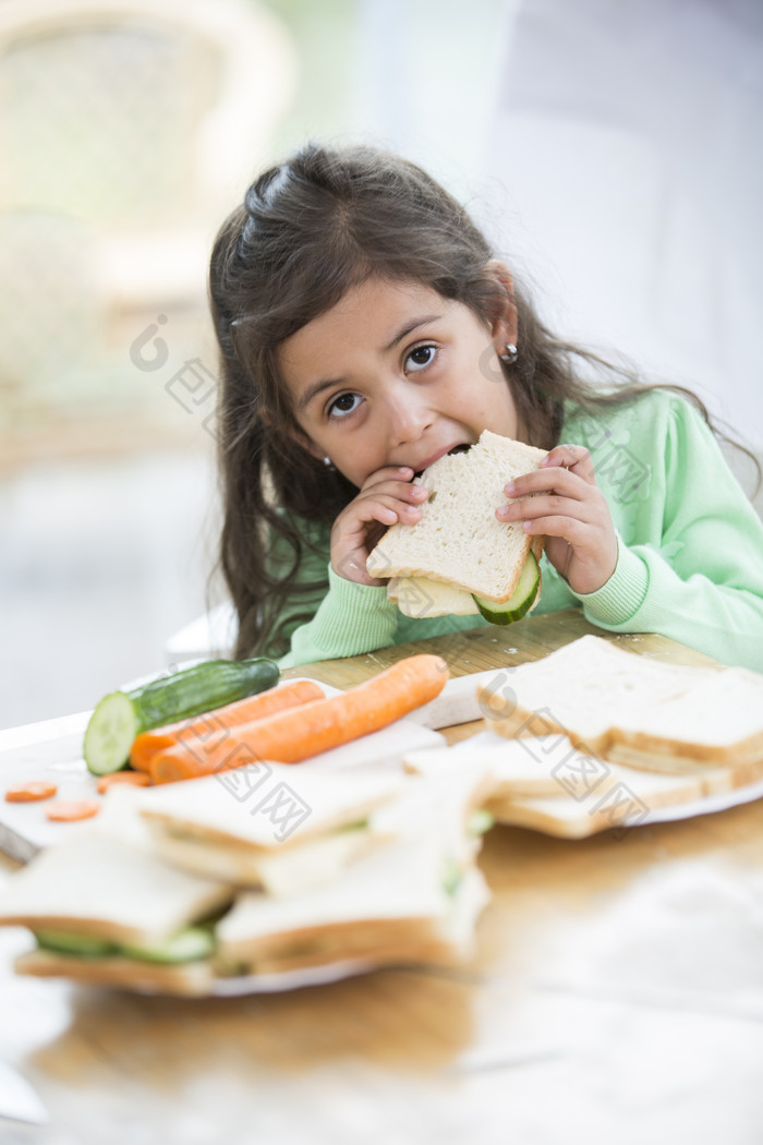 深色调吃面包的小女孩摄影图
