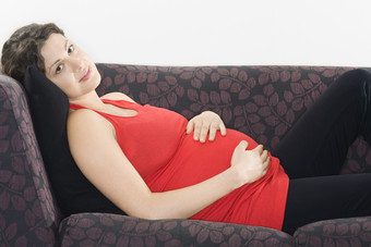 简约沙发上休息的孕妇摄影图