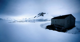 深色调雪中的小房子摄影图