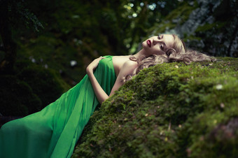 躺在岩石上的绿裙女人