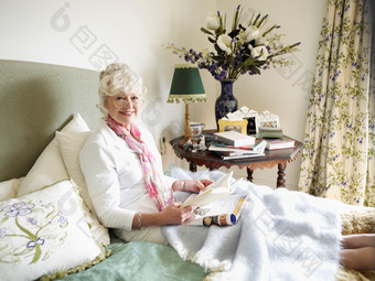 坐在床上看书的白发女人
