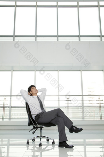 商务男士跷二郎腿坐在椅子上