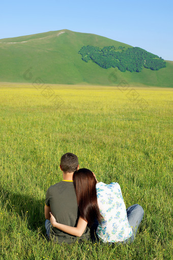 坐草地上的情侣背影