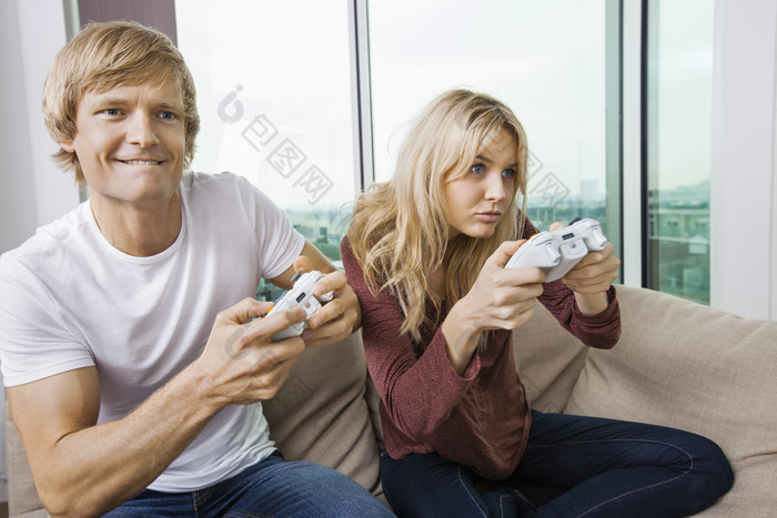 简约风玩游戏机的夫妇摄影图