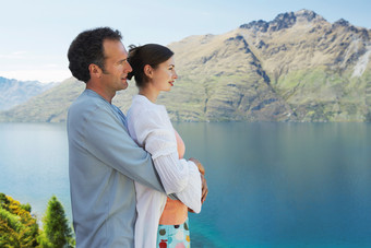 丈夫抱着妻子欣赏山水风景