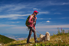 牵着小狗登山的男人