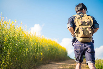 背着旅行包在野外的男子