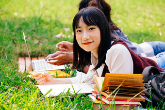 趴在草坪上看书的女孩