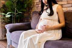沙发上抚摸孕肚的孕妇