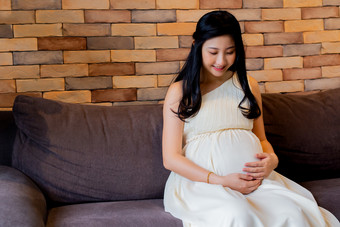 孕妇坐沙发抚摸孕肚