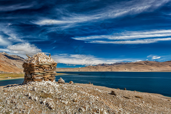 深蓝湖边的石堆摄影图片