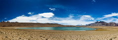 蓝天白云湖水沙地全景摄影图