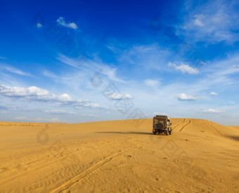 蓝天下正在<strong>沙漠</strong>中行驶的车