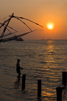 堡科钦码头夕阳下捕鱼的渔民