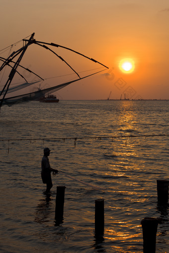 堡科钦码头夕阳下捕鱼的渔民