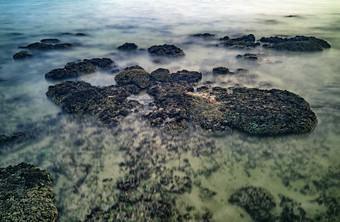 海边海水退潮露出岩石摄影图
