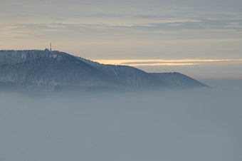 户外景色天空白雾中的山峰摄影图