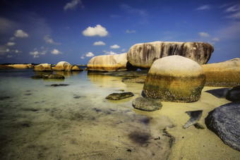 海滩沙滩海水中的岩石摄影图