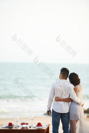 浅蓝沙滩上的情侣摄影图