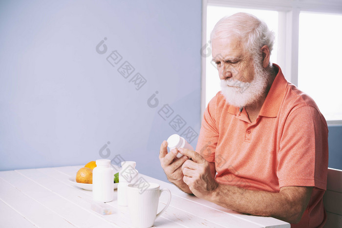 灰色调吃药的老人摄影图