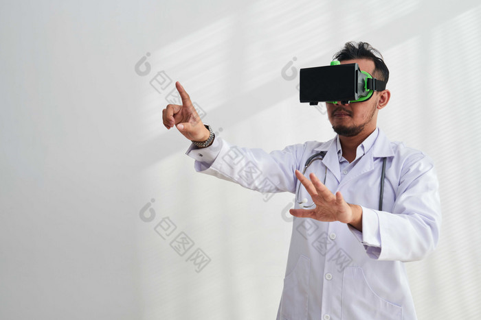 灰色调玩VR游戏的医生摄影图