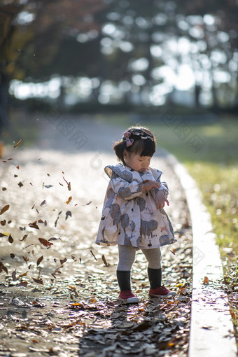 可爱的小孩在落叶中站立