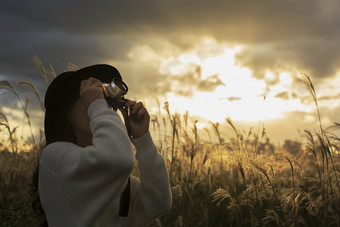 夕阳下拿着相机拍照<strong>的</strong>女孩