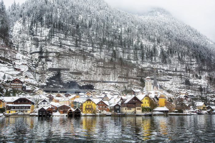 积满雪花的山林湖泊和建筑群风光图