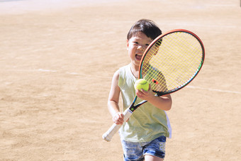 小男孩拿着网球拍