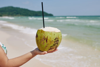热带海边的手拿椰子的人